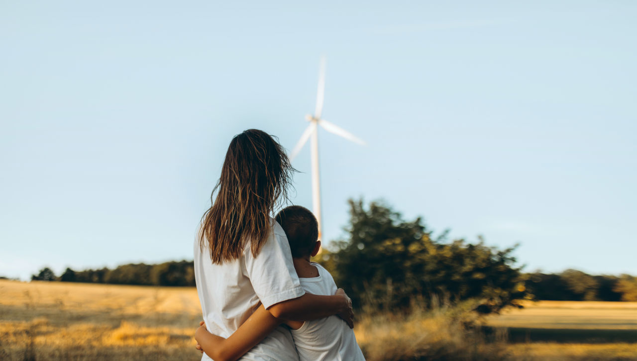 a woman hugging and child in a wind farm