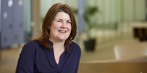 woman with brown hair sitting down and smiling